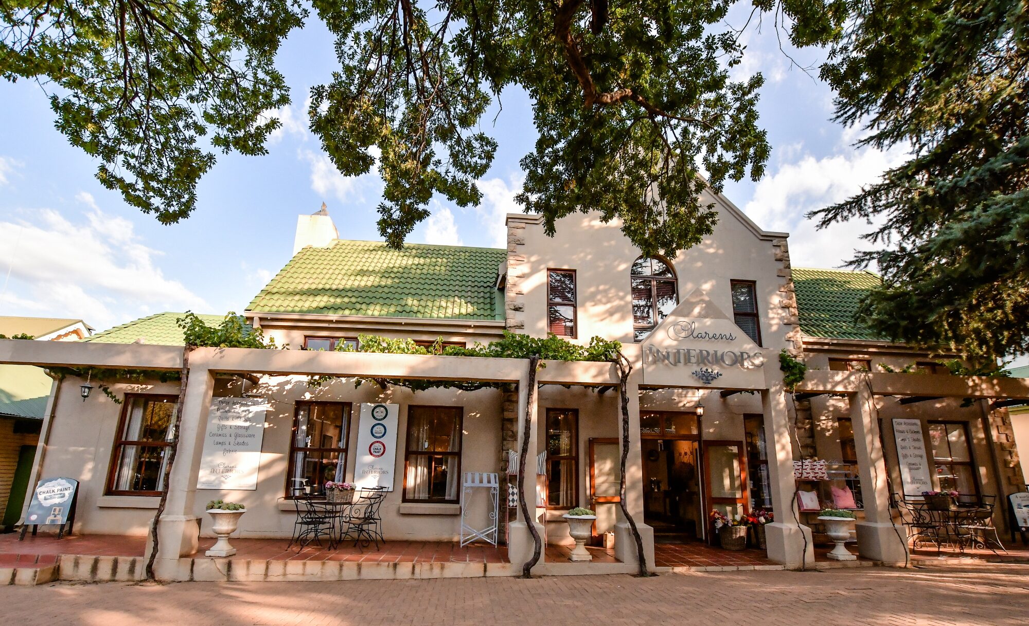 Sandstone shopfronts and shady trees along Main Street in Clarens village, Free State