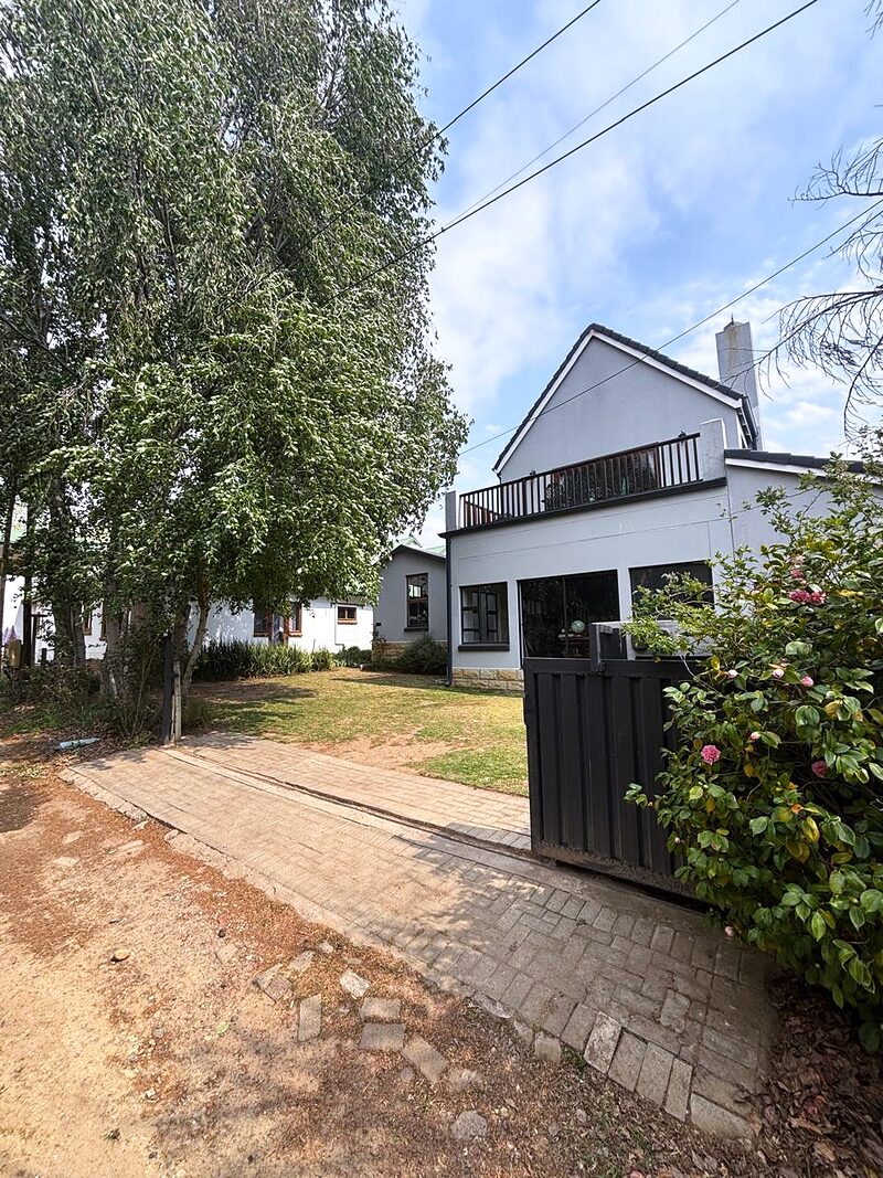 The paved driveway and motorised gate at the entrance to the parking