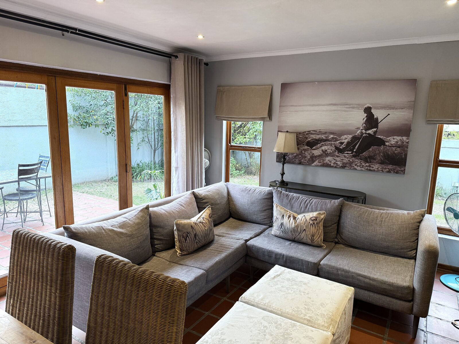 Open plan living area in The Studio with a deep corner couch and stack doors